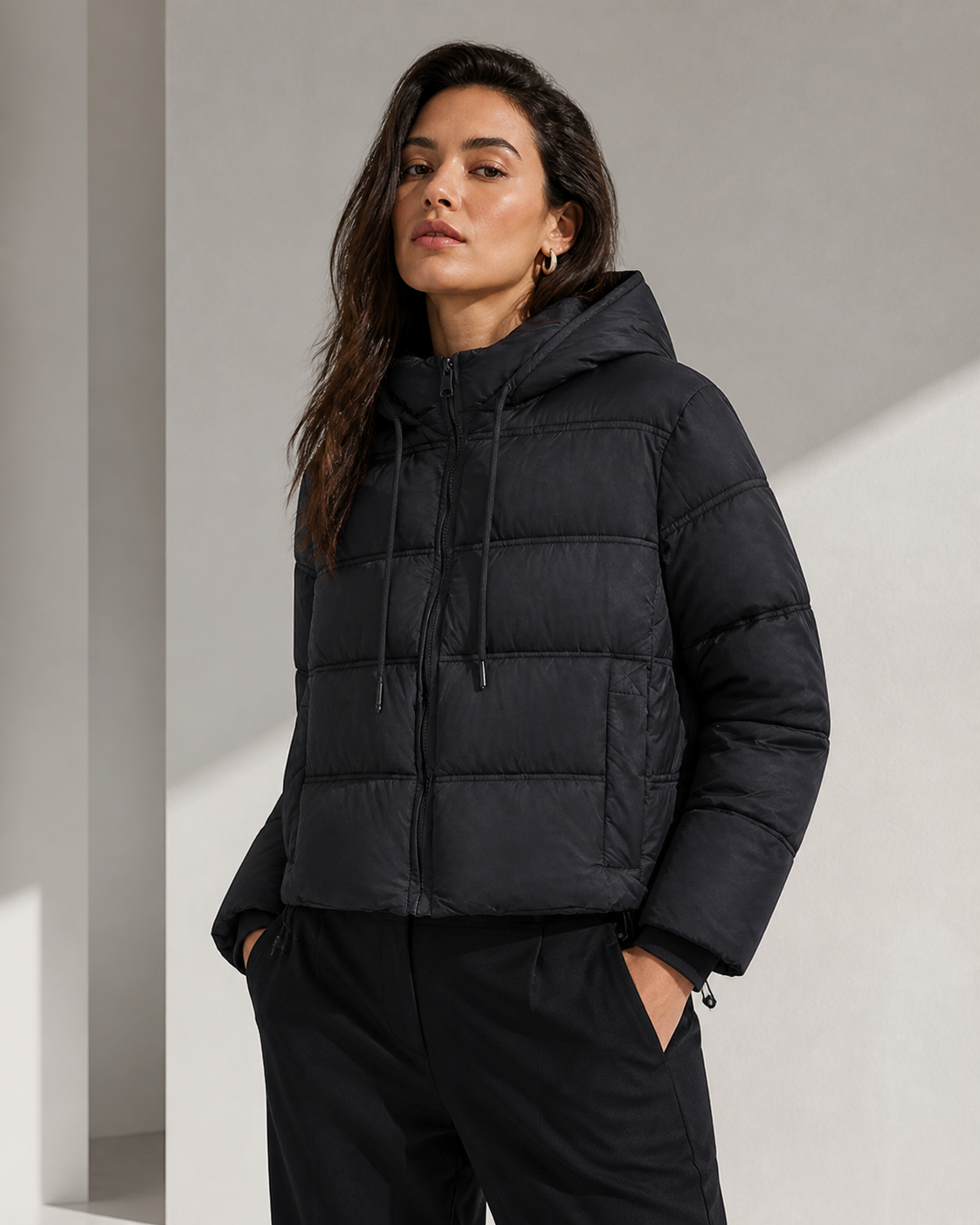 Model wearing black hooded puffer jacket